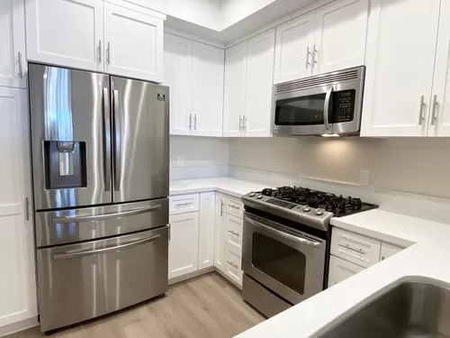 New fridge and updated cabinets in the kitchen of apartment #201 - Palm Court