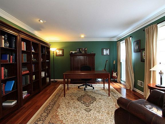 Large office or den with crown molding and recessed lights.