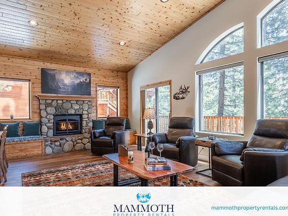 Cozy living room with fireplace, ample seating and beautiful mountain views through the windows. A great place to relax after a day of winter activities!