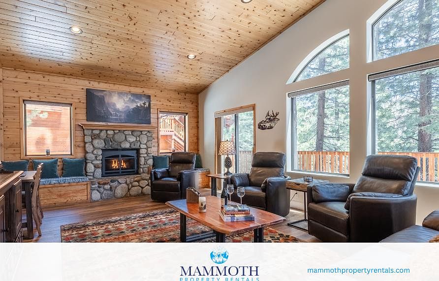 Cozy living room with fireplace, ample seating and beautiful mountain views through the windows. A great place to relax after a day of winter activities!