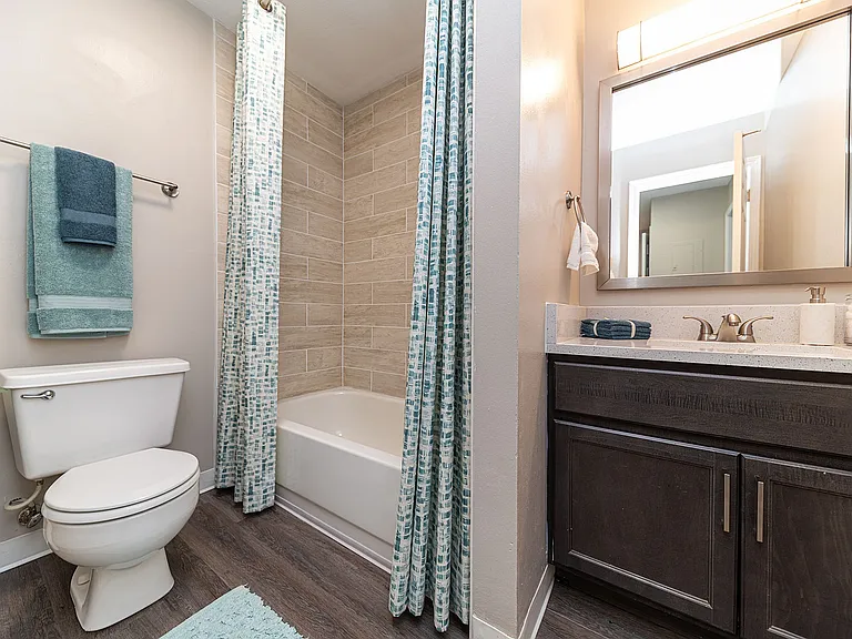 Bright bathroom with granite counters and bathtub