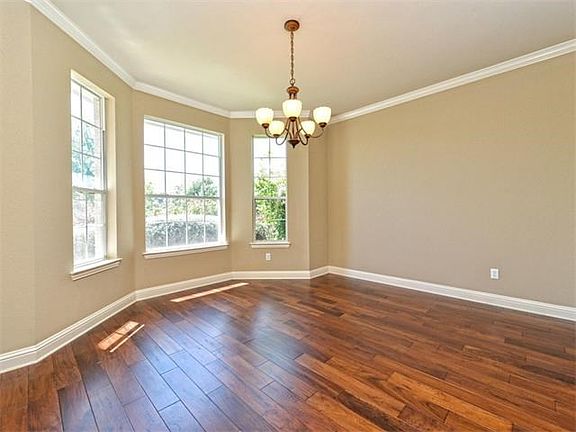 The formal dining room has a bay window and gleaming hardwood floor. It also features crown molding 