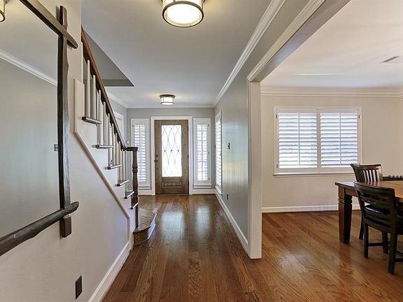 The entry is spacious with a large wood and wrought iron and glass door. The master and second bedroom are to your left and the dining room is to your right. Wood floors are throughout the 1st floor living areas and stair case.