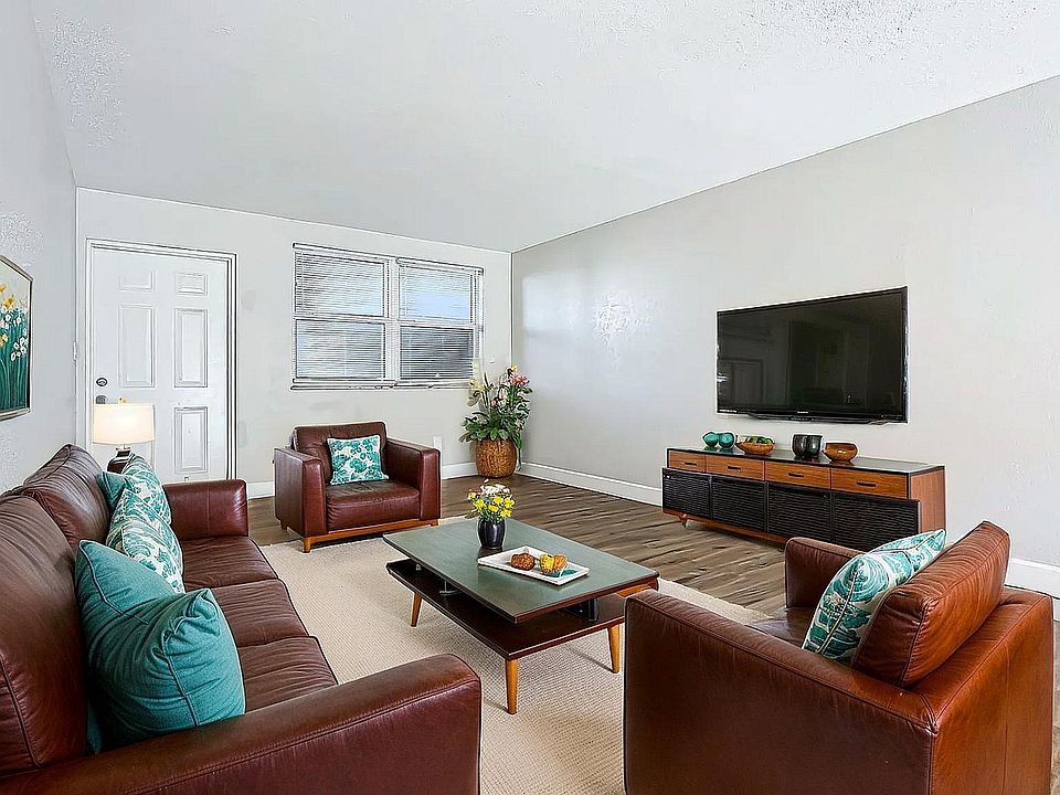 Inviting living room featuring sleek leather furniture, vibrant decor, and a large flat-screen TV for a modern lifestyle.