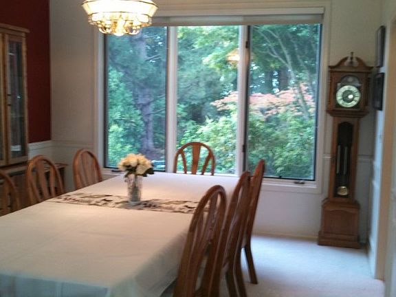 High ceilings and bay windows bring in lots of outside light adding to the sense of elegance of the living room, sunken just a step below the foyer