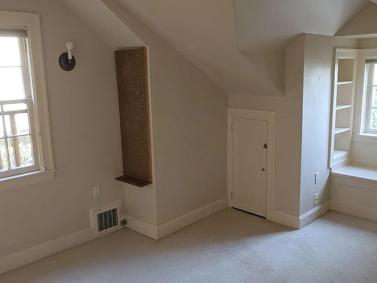 Bedroom #3 has built in bookshelves, reading nook, and closets. Pegboard and old light fixtures are gone