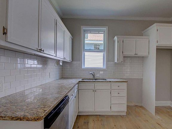 Fully updated kitchen offers tile backsplash and solid surface countertops.