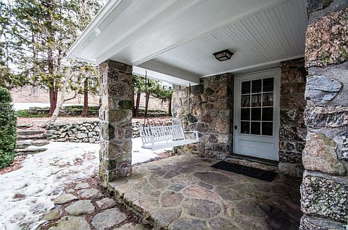 Covered Stone entry with of course a porch swing