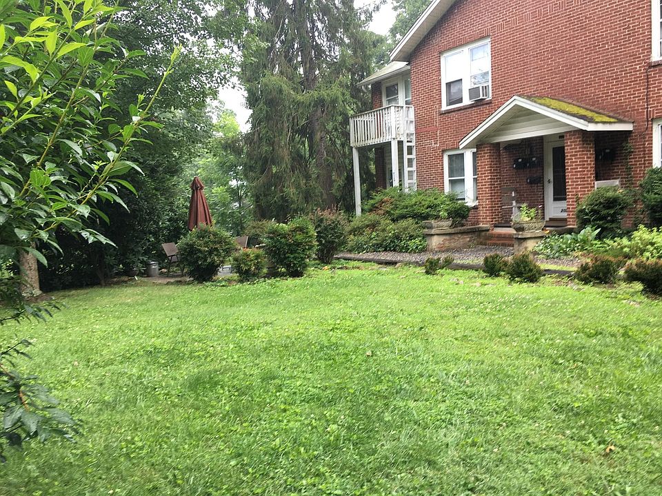 Summertime view from the street. Indoor stairwell accesses Apartment number four, which (from this vantage point) is the top left. The Furnished patio is behind bushes on the left front side of the building Parking is behind the building.
