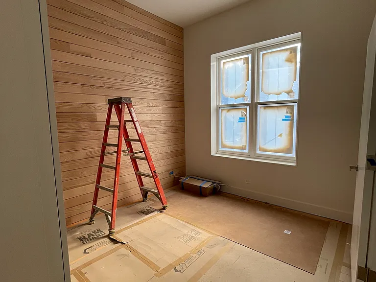 In-progress photo of Bedroom 1. Fits a king-size bed. Has a wooden wall. Has its own bathroom attached.