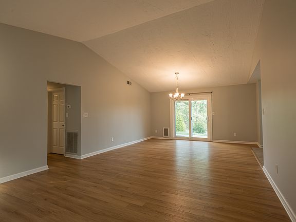 Open living/dining area with vaulted ceiling.