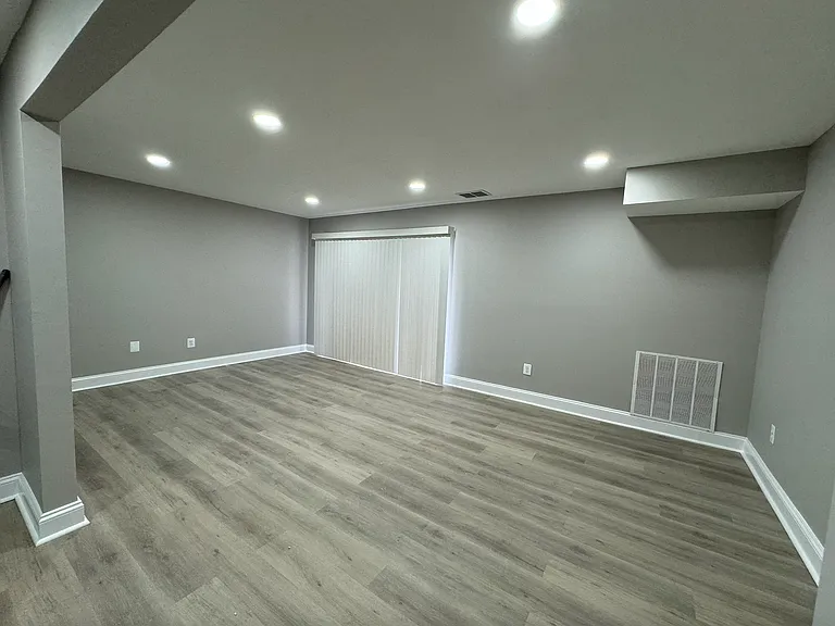 Living room area with curtain on sliding glass door.