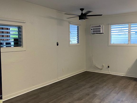 Well lit with lots of windows, ceiling fan and window unit air conditioner,