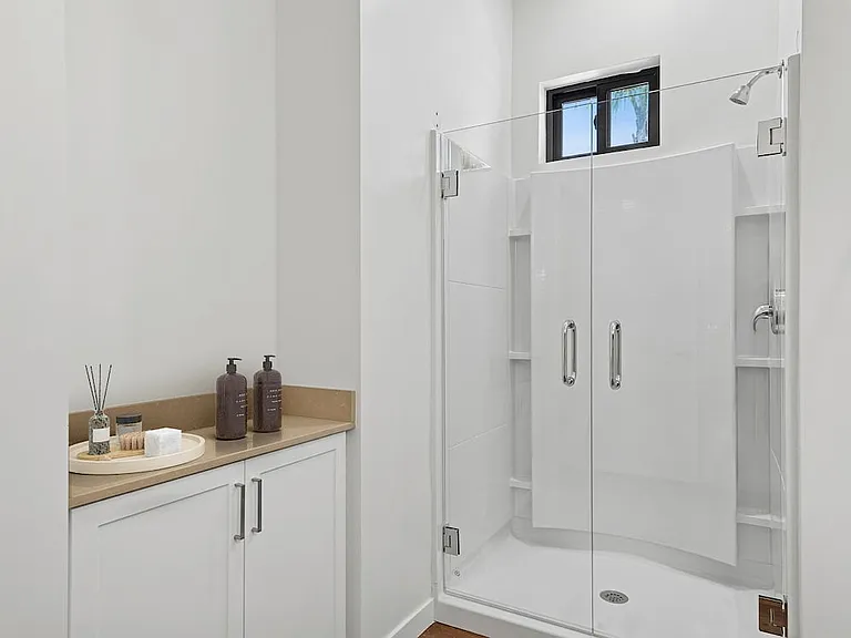 Freestanding Home bath with beige quartz countertop and white cabinetry
