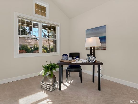 Main floor office with French doors and vaulted ceilings.