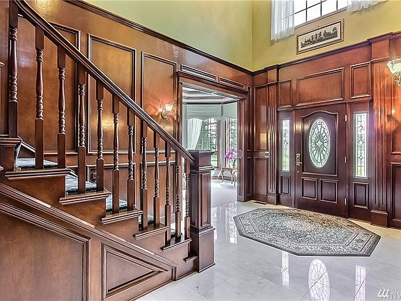 The Grand Foyer is highlighted by a soaring ceiling and spiraled staircase.  The deep and rich carpentry is warm and inviting.