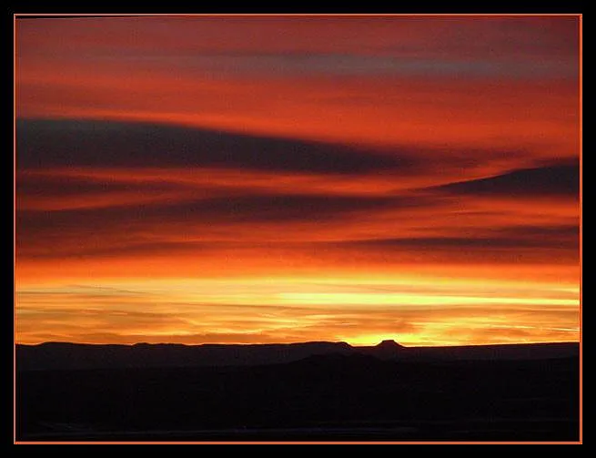 The Pedernal, at Abiquiu 72 miles west, that Georgia O'Keefe painted many times. This is a real sunset telephoto.