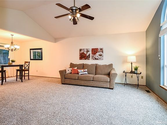 View from Entry - Living Room w/New Carpet!  Light & Bright with Vaulted Ceilings, Ceiling Fan & Oversized Windows.