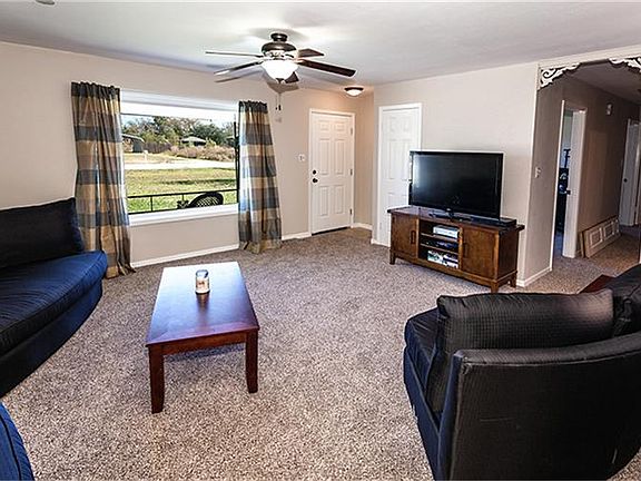 Living room with neutral colors, new carpet and open to Kitchen