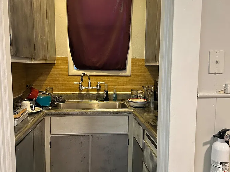 Compact kitchenette with double-basin sink, ample cabinetry, and surrounding countertops for everyday prep and cleanup.