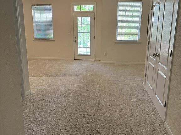 1st floor rec room with entry to back patio that overlooks community pool