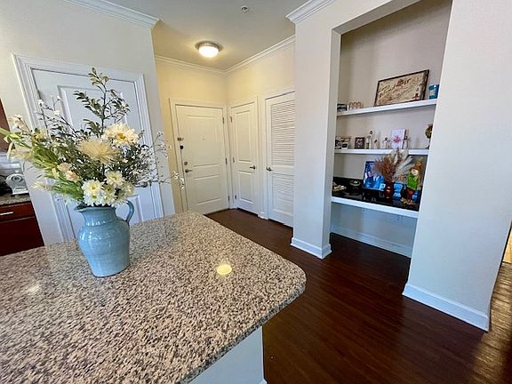 Entryway and desk. Washer/dryer closet to left of desk and shelves.