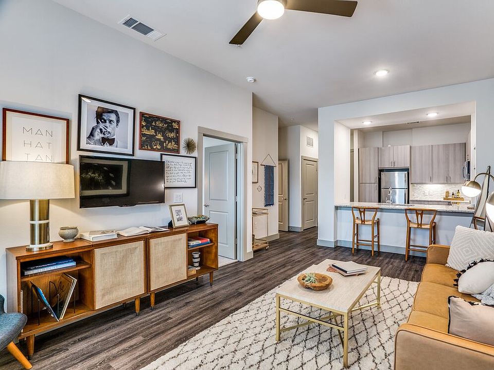 Gray finish package kitchen, living, and dining area with hard surface flooring and ceiling fan