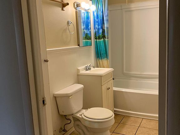 Bathroom with full shower / bathtub. Linen closet to left of door not visible.