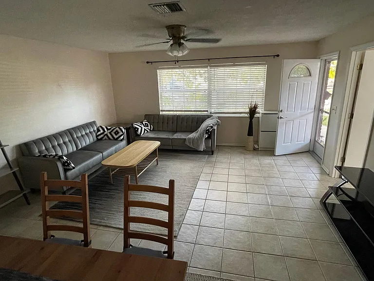 View of the living room from the dining area with a large flat screen tv on the right. Sofas not available.