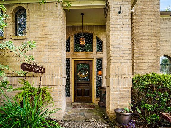 The front covered porch gives a welcoming yet stately feel with the large windows and wood stained glass pane front door.