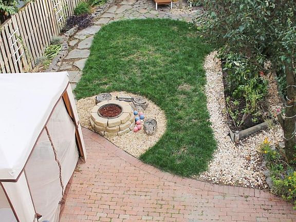 newly landscaped back yard with fire pit, multiple seating a