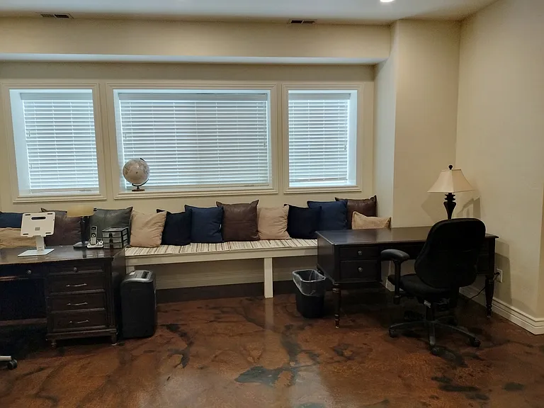 This spacious office boasts 10-foot basement ceilings, large windows for natural light, and two desks equipped with monitors and outlets for teleworking. Enjoy a treadmill for break-time exercise and a cozy fireplace to keep you comfortable.