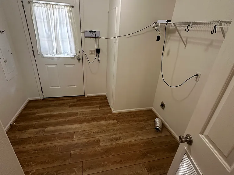 Laundry room with additional back door entrance.
