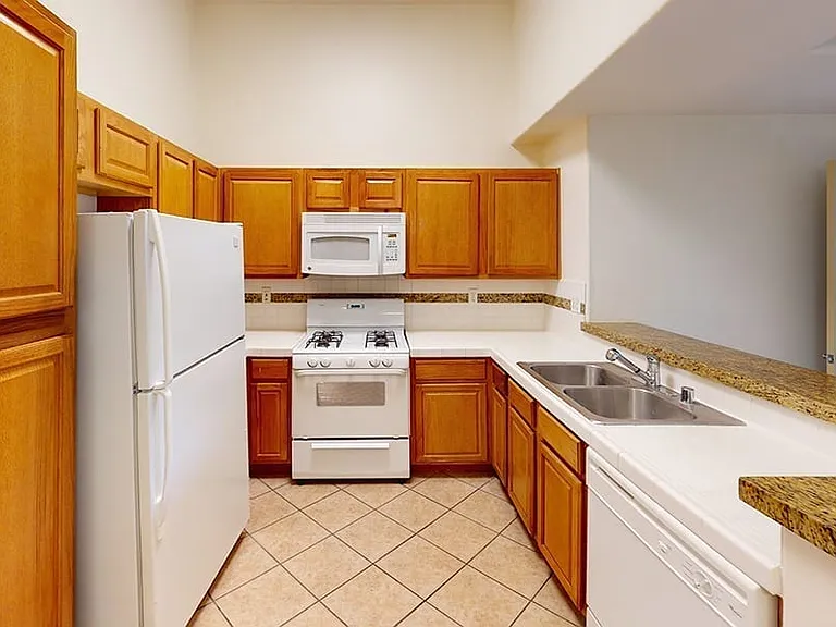 Apartment kitchen with tile flooring.