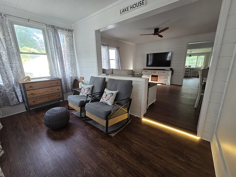 Enclosed front porch w/ rocking chairs. View is looking into the living room then kithen, then dining room to backyard.