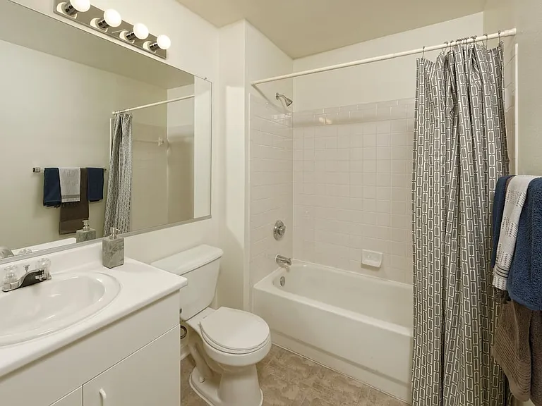 Classic Package I bath with white cabinetry, white laminate countertop, and vinyl tile flooring