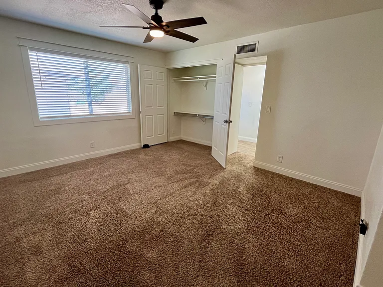 Large space master bedroom with new fan, closets and large window.