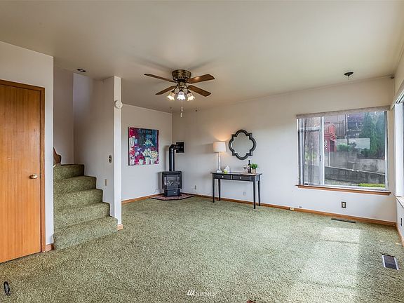 Enter into Living Room on Right w/Oversized Windows Offering Wonderful Valley Views & Surrounding Mountains. Freestanding Gas Fireplace/Stove & Ceiling Fan to Circulate Airflow.>