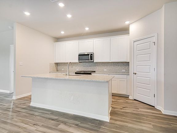 The kitchen features linen-colored cabinets and granite countertops.