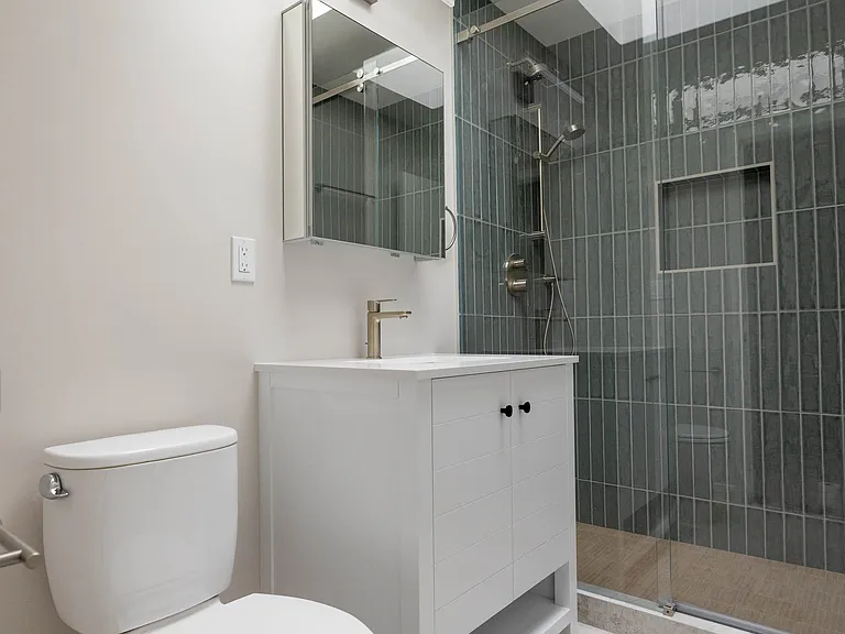 Bathroom's tile work is flooded with natural light above