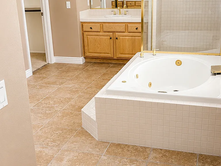 Large primary bathroom with soaking tub, shower enclosure, and tile flooring