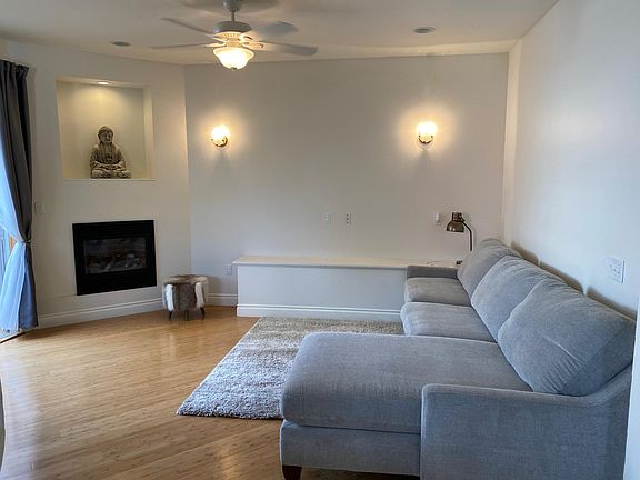 Good sized living room with remote control fireplace and CB2 lighting.