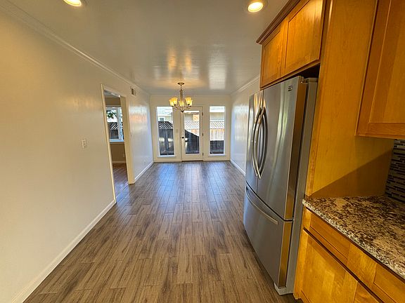 In kitchen, looking into dining area. Tile floor.