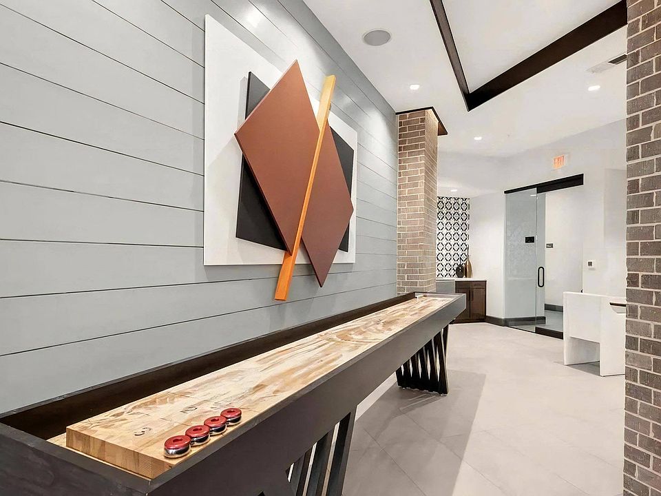 Modern Game Lounge Featuring Shuffleboard and Artistic Decor
