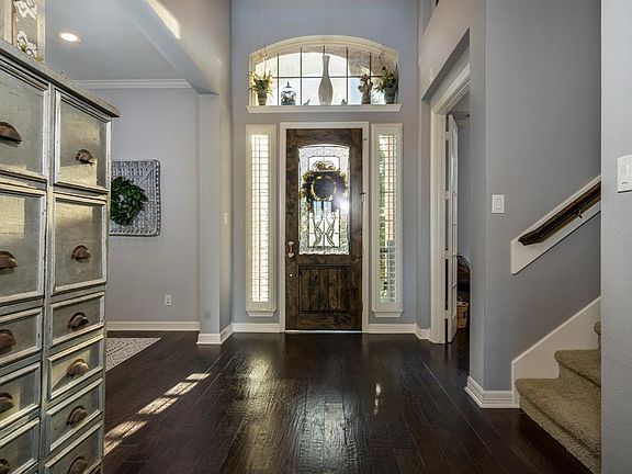 A picture perfect entryway with a knotty alder leaded glass door with an arched window and sidelight windows surely makes a statement!
