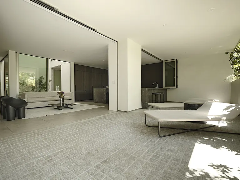 Sleek Living Space with Minimalist Elegance _ Designed for both relaxation and entertaining, this indoor-outdoor flow allows for an organic connection to nature through expansive sliding glass doors with flush sill.