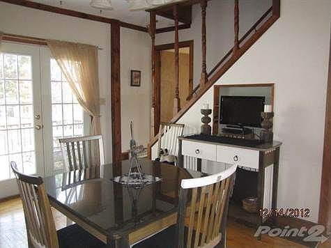 Dining Room with Hardwood floors, French doors to Deck and Open Staircase to 2nd Floor Bedroom.