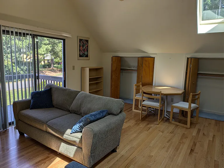Great room -- couch, dinette set, two closets, sliding door to deck