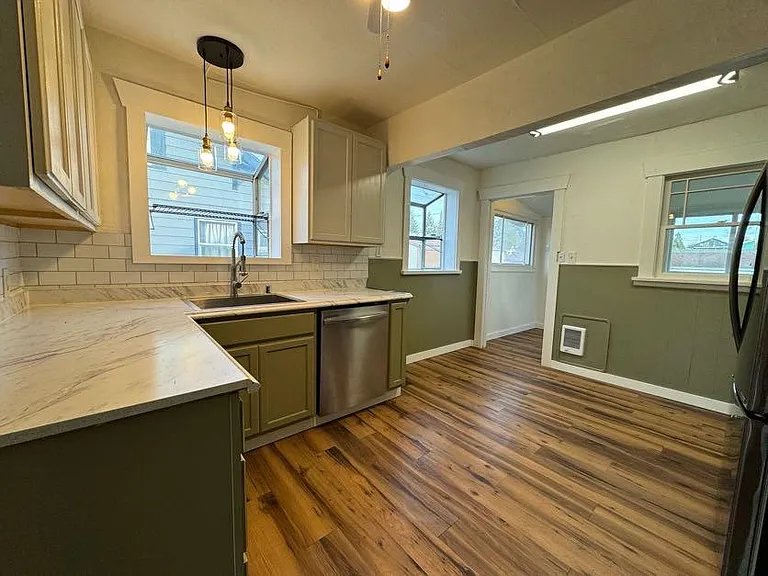 Kitchen with newer cabinets, stainless steel appliances, updated lighting and dishwasher.