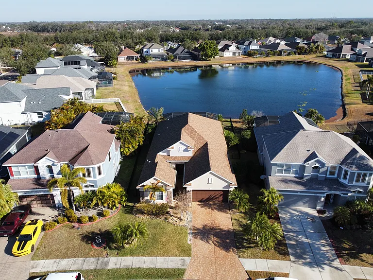 Aerial view of house with pond in rear